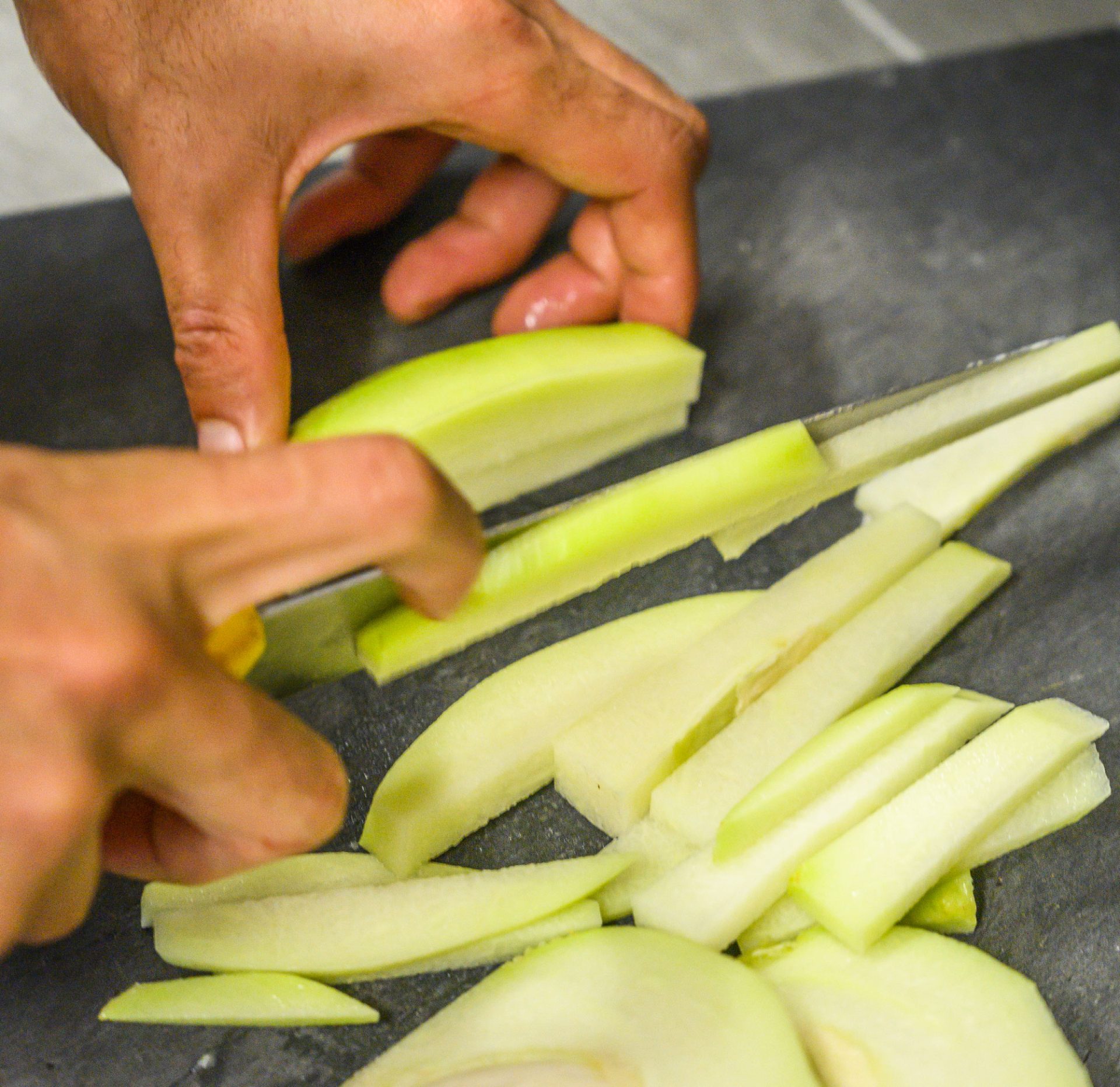 Man slicing chouchou de Salazie