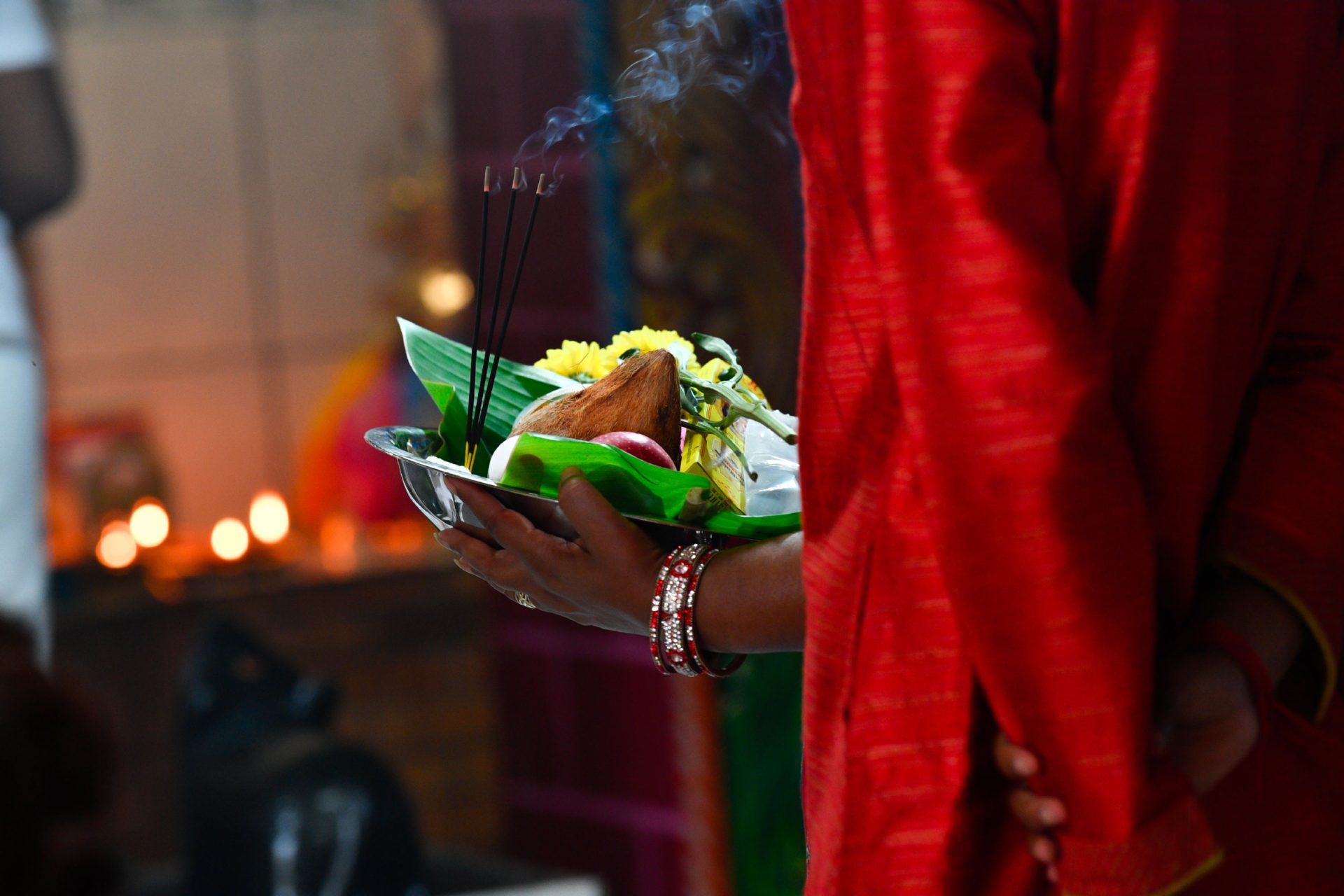 Frau, die ein Tablett mit Opfergaben für das tamilische Neujahr 2023 trägt