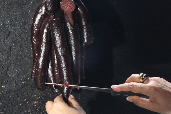 Frau schneidet Blutwurst traditionell reunionesische Küche