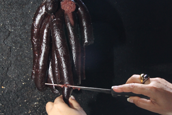 Mujer cortando morcilla tradición cocina reunionesa