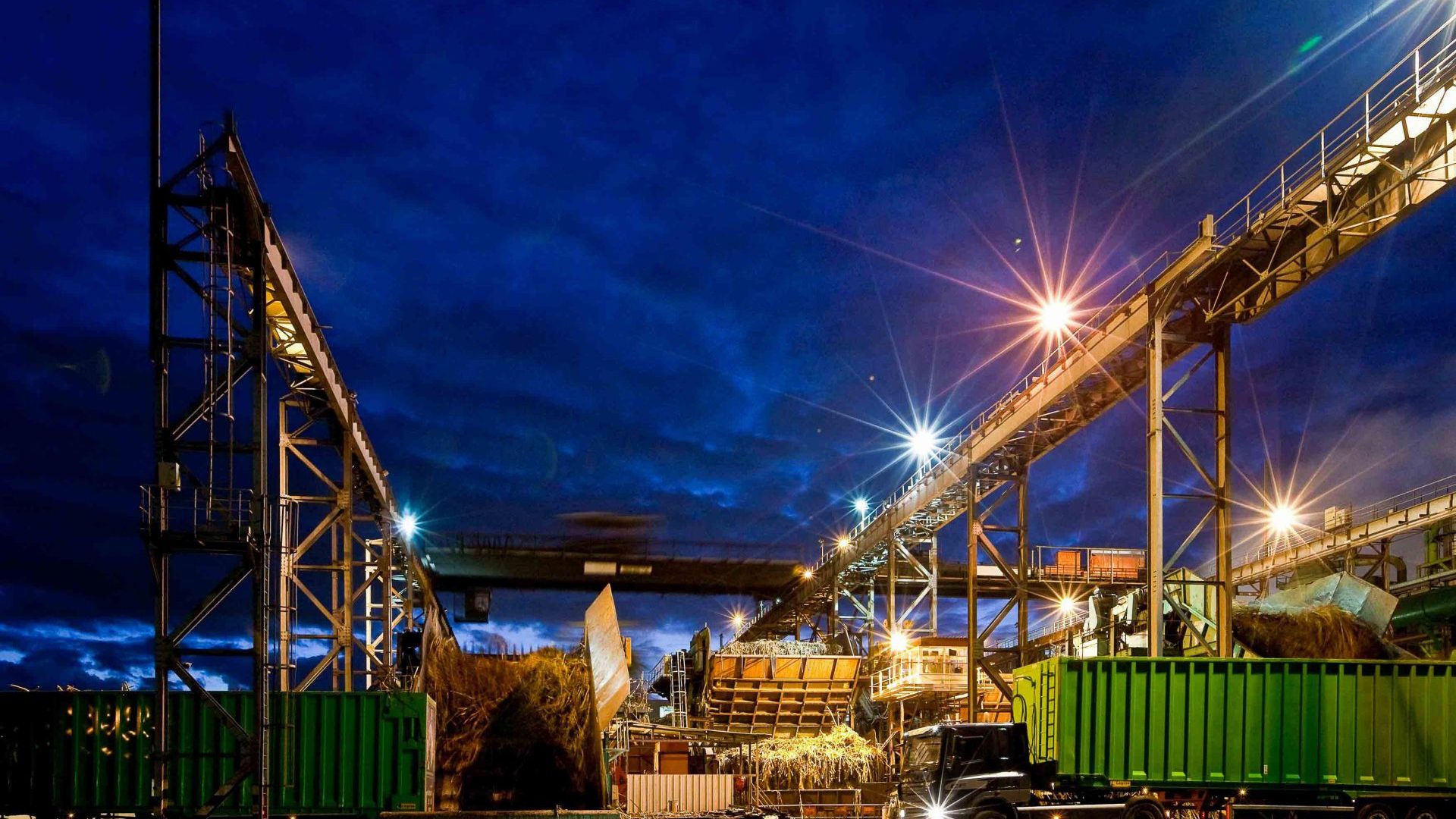 Bois Rouge-Fabrik nachts mit Zuckerrohr-LKWs beleuchtet