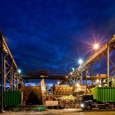 Bois rouge factory illuminated at night with sugar cane trucks