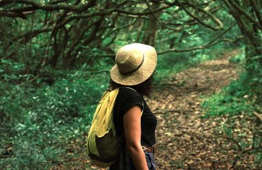 Mujer con sombrero caminando por el bosque - Bienestar en el este de Reunión