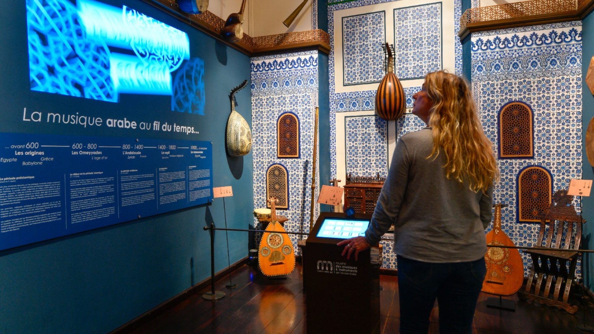 Femme qui regarde des instruments de musiques dans me musée des musiques et instruments de l'Océan Indien.