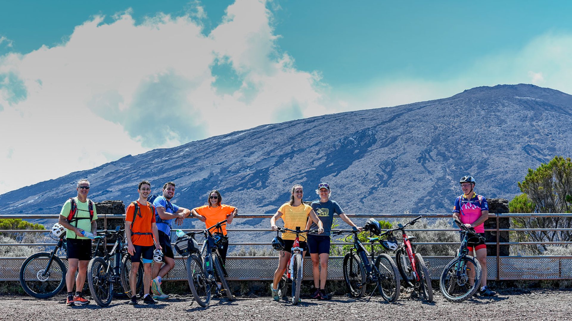 Excursionistas en bicicleta frente al volcán Piton de la Fournaise