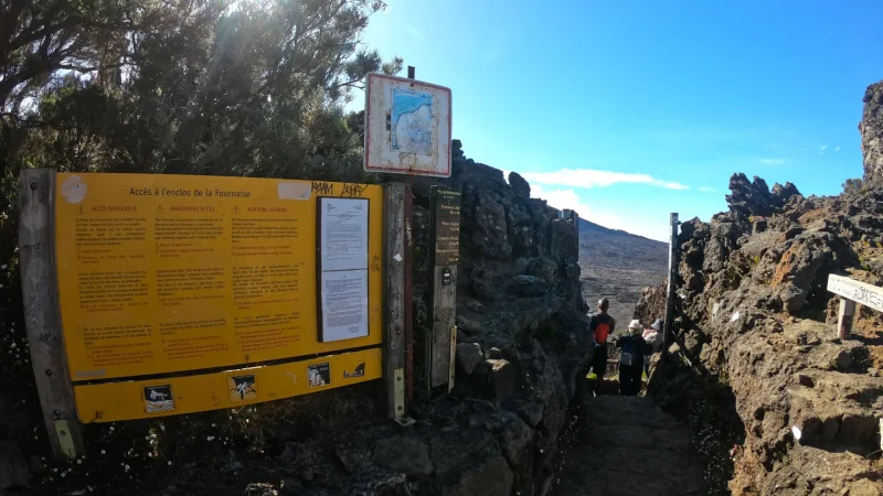 People are on the hiking trail at the entrance to the Fournaise enclosure